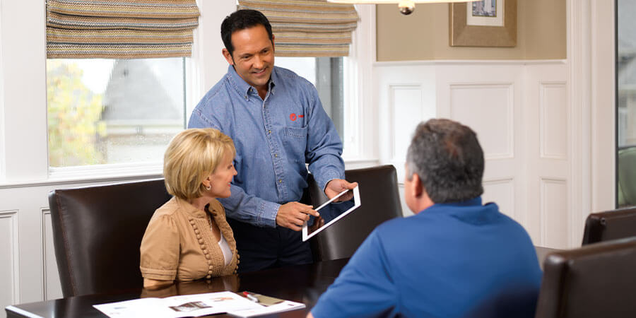 Service technician explaining referral program to homeowners